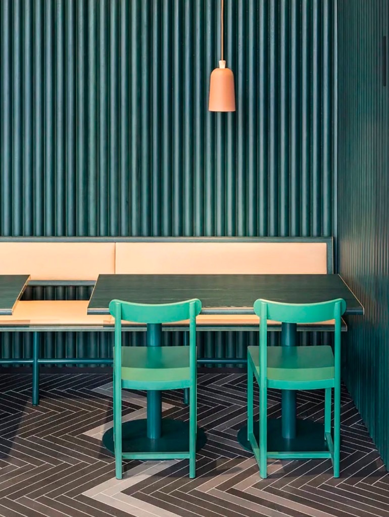 Sittvrå på Finefood med tealgrön väggpanel och persikofärgad soffa.